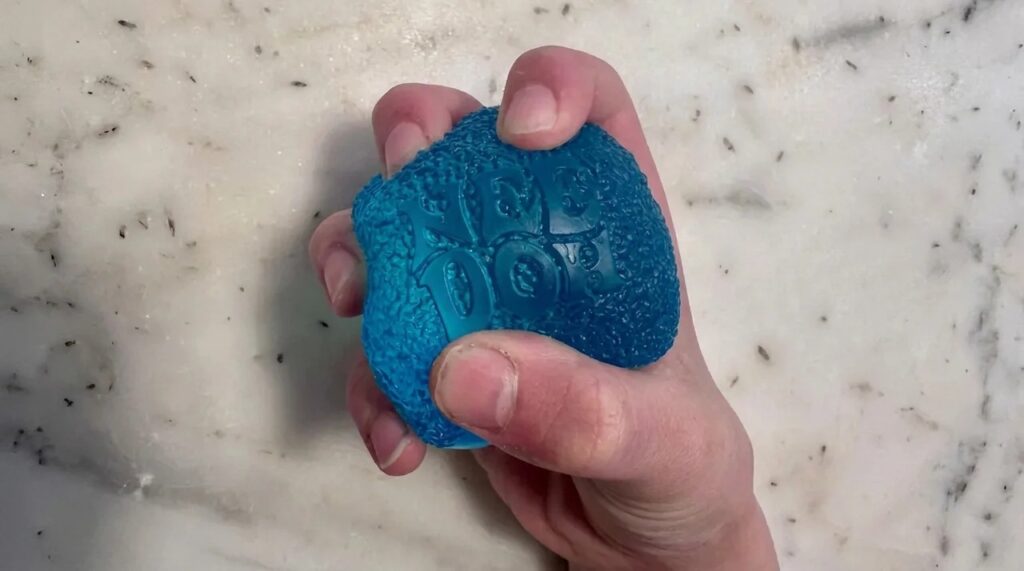Person holding blue Needoh in hand.