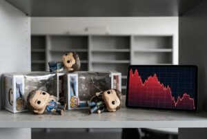 Funko Pops on a table with a declining chart